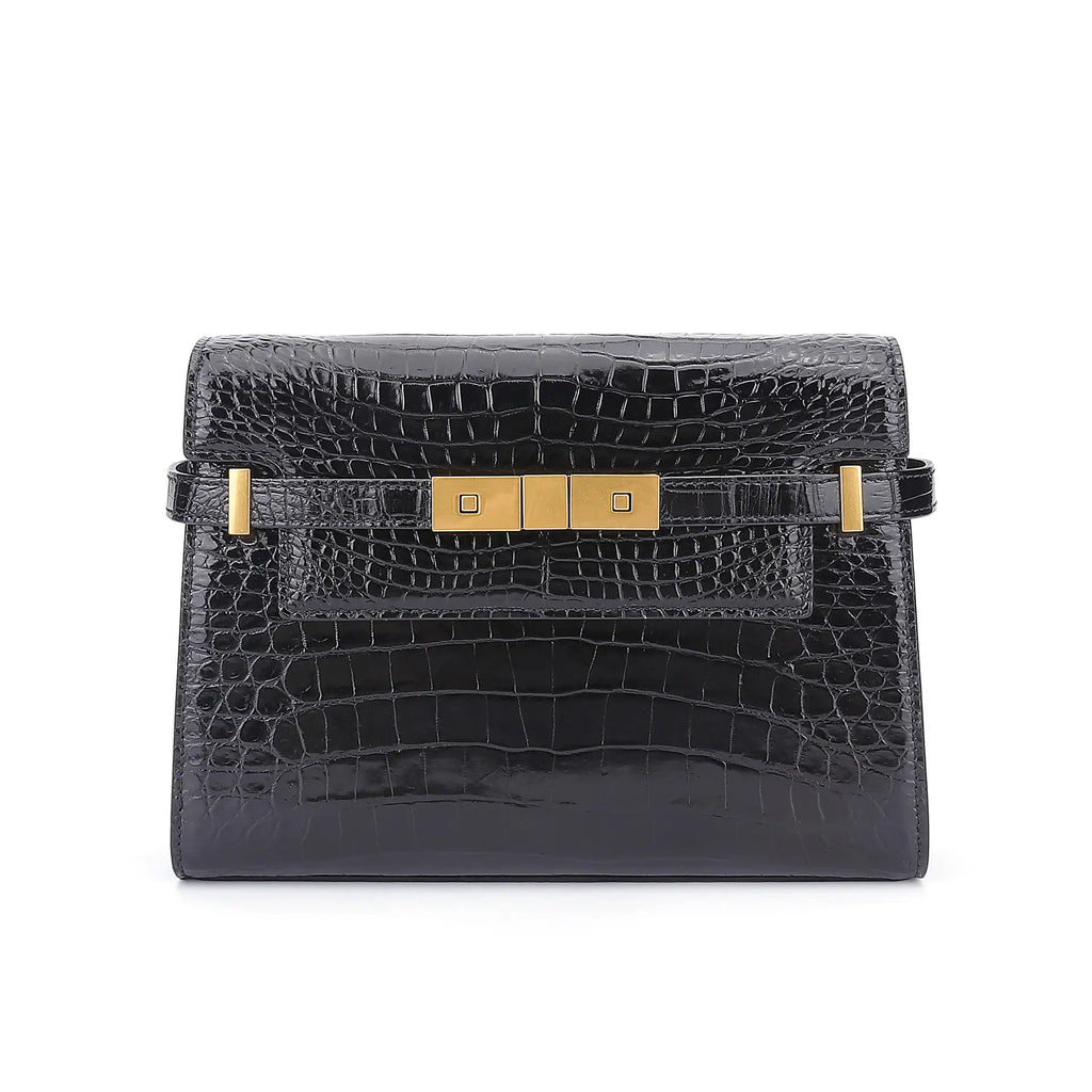 Black crocodile skin handbag with gold hardware on a white background