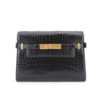 Black crocodile skin handbag with gold hardware on a white background