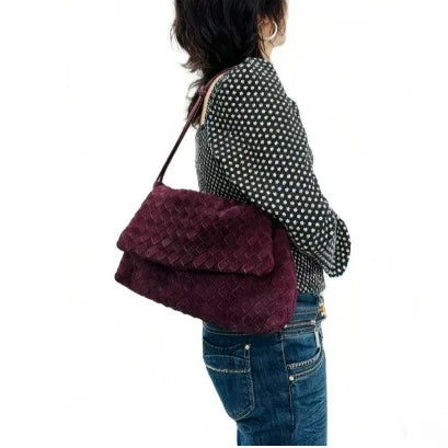 Person wearing a black and white polka dot shirt with a purple textured handbag on a white background, Suede Leather Woven Bags.